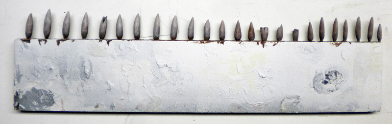 Rangée de dents pointues sculptées alignées sur un support blanc pour le Squig