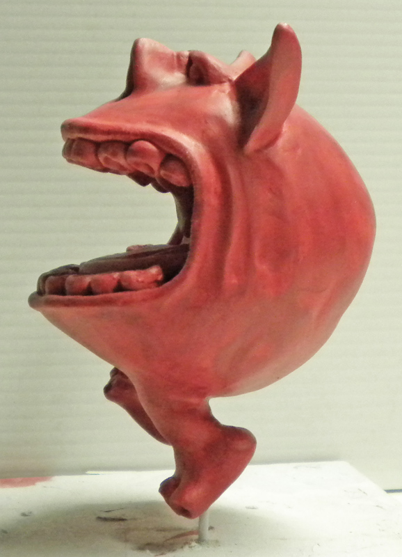 Squig rouge sculpté à grande échelle, gueule grande ouverte montrant ses dents, vue de profil