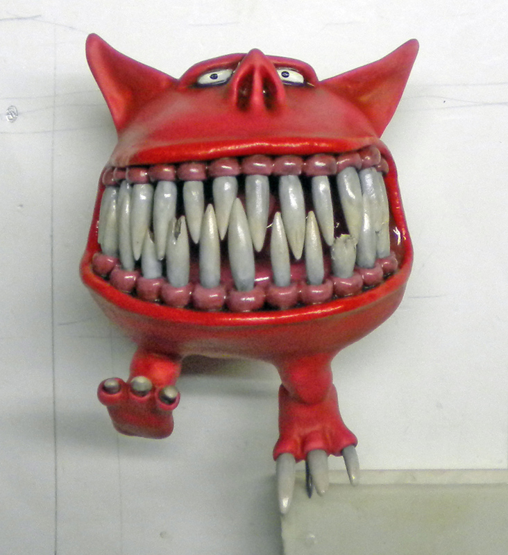 Squig rouge à grande échelle avec énorme gueule de dents blanches et petites pattes griffues