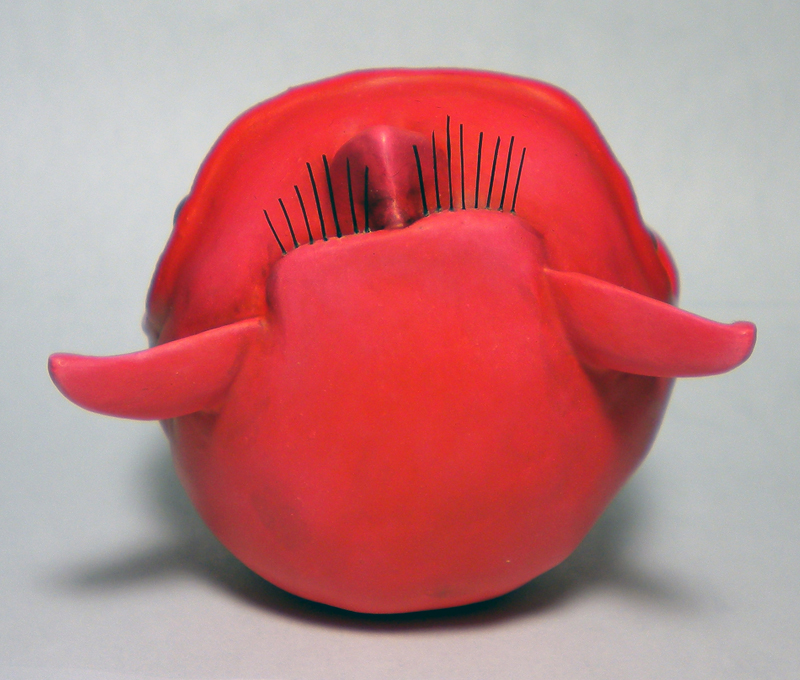 Squig rouge sculpté de dos avec piques métalliques sur le dos et grandes oreilles