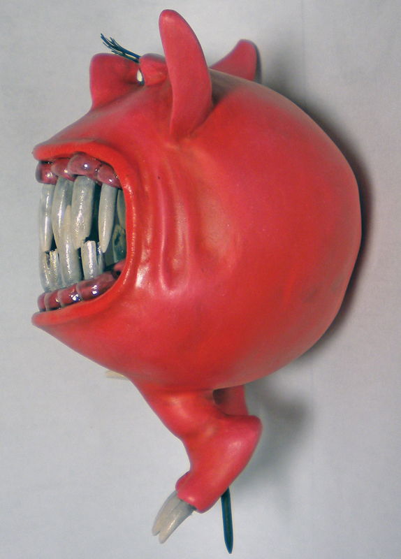 Squig rouge sculpté à grande échelle, gueule ouverte montrant ses grandes dents blanches