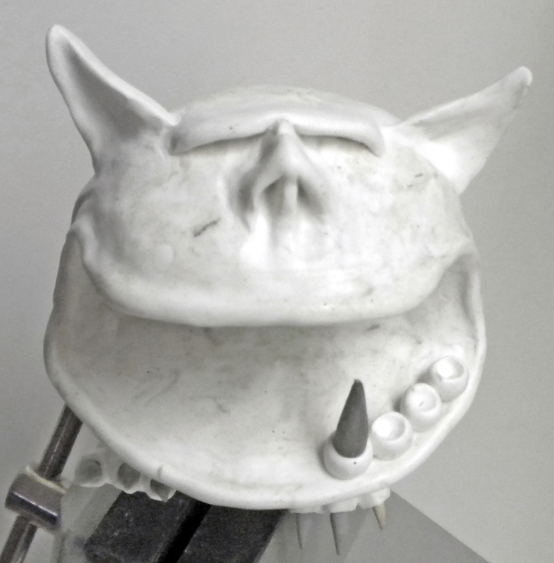 Sculpture en mastic blanc d'une tête de Squig avec oreilles pointues, grande bouche et crocs