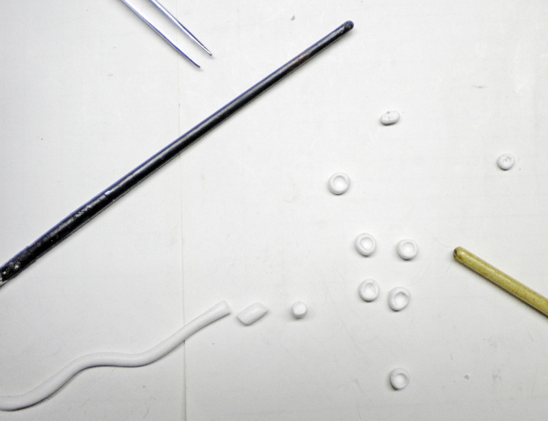 Petites billes et formes en pâte modelée séchant sur un plan de travail avec outils de sculpture