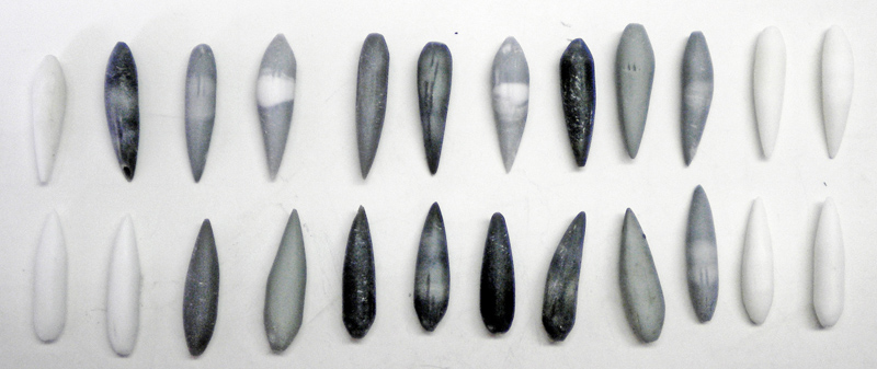 Dents pointues en résine peintes en dégradés de gris alignées sur fond blanc