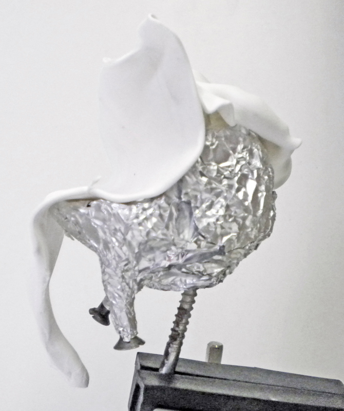 Armature en papier aluminium d'un Squig recouverte de pâte à modeler blanche en cours de sculpture