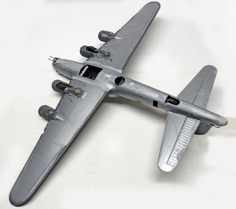 Maquette de bombardier quadrimoteur gris en cours de montage vue de dessus