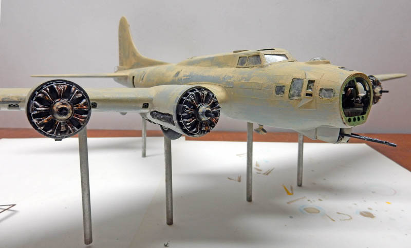 Maquette de bombardier quadrimoteur sans hélices montée sur tiges métalliques, moteurs en étoile détaillés en cours de peinture