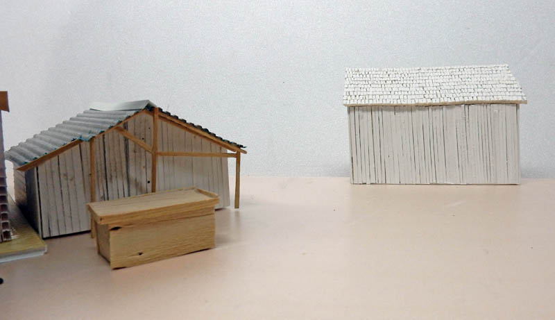 Maquettes de petits bâtiments en bois et carton, hangars avec toitures et bardage, en construction