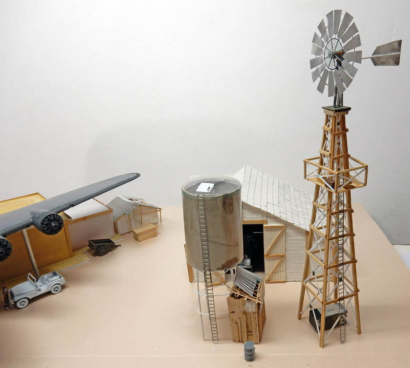 Maquette de diorama avec éolienne, château d'eau, hangar, avion et véhicule anciens