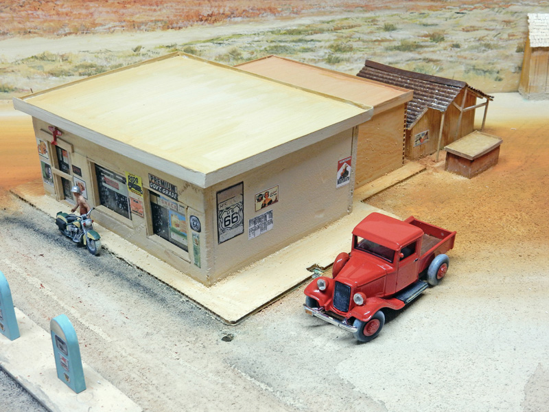 Diorama de station-service Route 66 avec pick-up rouge et moto devant une boutique du désert