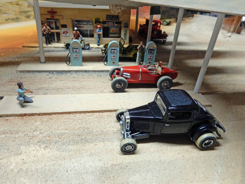 Diorama de hot rods devant une station-service vintage avec figurines et pompes à essence