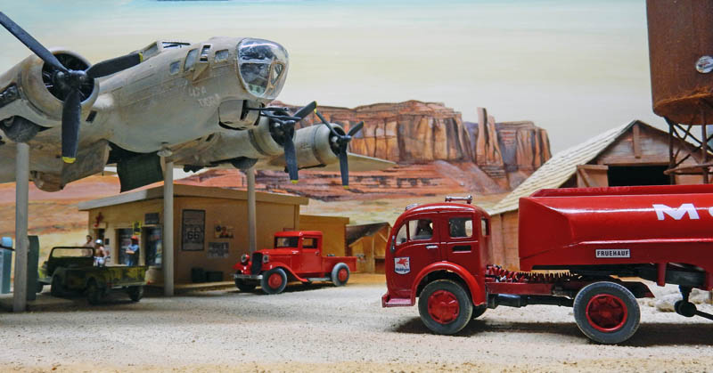 Diorama de maquettes avec bombardier B-17, camion-citerne rouge et station-service devant un décor de Monument Valley