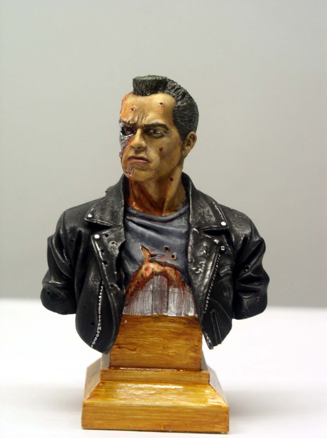 Buste peint du T800 en blouson de cuir, visage endommagé révélant l'endosquelette métallique, sur socle bois
