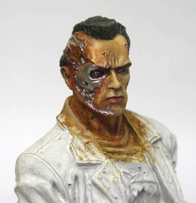 Buste T800 peint, visage abîmé révélant l'endosquelette métallique et l'œil rouge, veste blanche