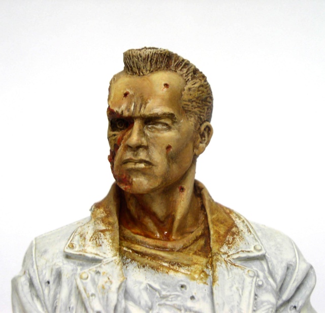 Buste peint du T800 au visage endommagé montrant blessures et œil rouge, veste claire
