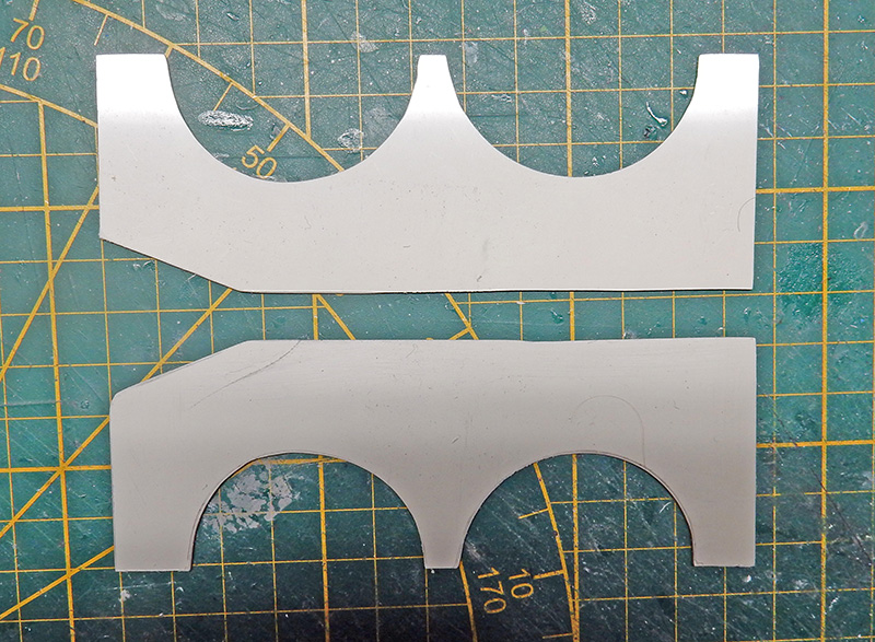 Deux pièces de carte plastique découpées avec passages de roues sur tapis de coupe vert