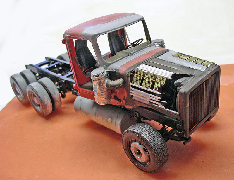 Maquette de tracteur dépanneuse rouge patiné aux détails de moteur apparents vue trois quarts