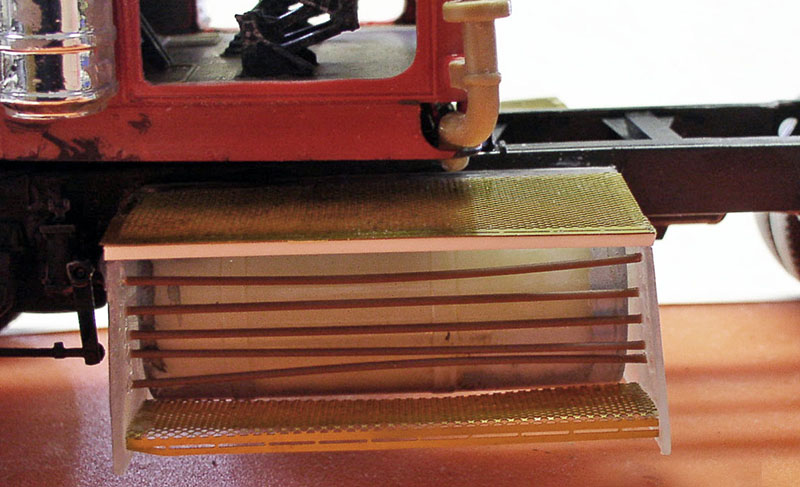 Coffre latéral en construction sur maquette de dépanneuse rouge avec plaques photodécoupées dorées