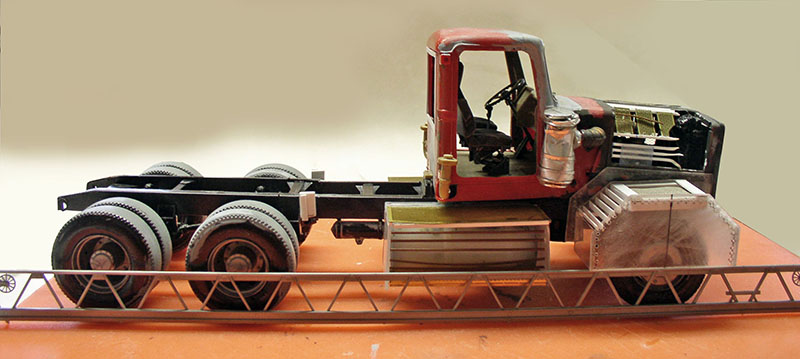 Maquette de châssis-cabine de dépanneuse rouge vue de profil avec plateau métallique