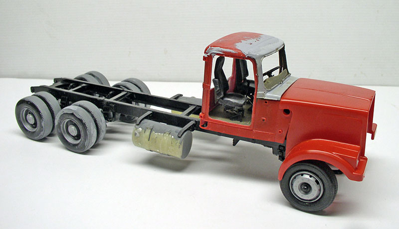 Maquette de camion dépanneuse à cabine rouge sur châssis noir, vue trois quarts arrière
