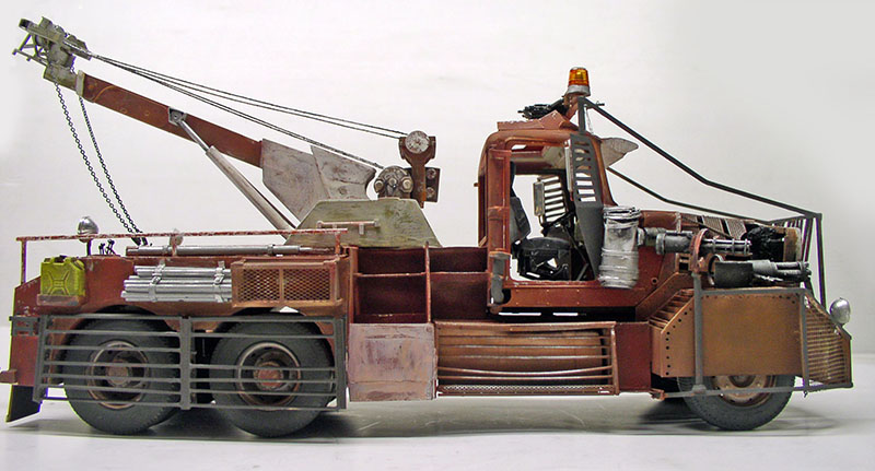 Maquette de dépanneuse rouillée vue de profil avec grue, gyrophare et moteur apparent
