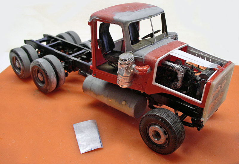 Maquette de camion dépanneuse rouge et gris en construction, châssis, moteur et cabine visibles