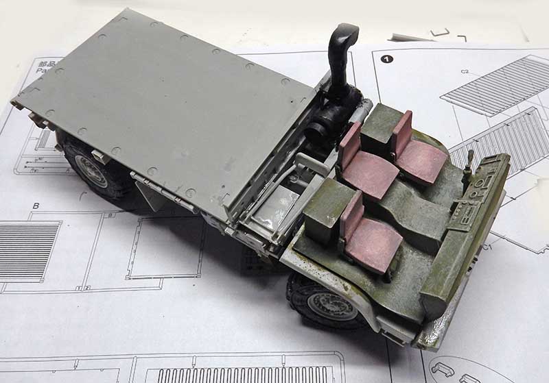 Maquette de véhicule militaire blindé en montage avec sièges intérieurs posée sur la notice