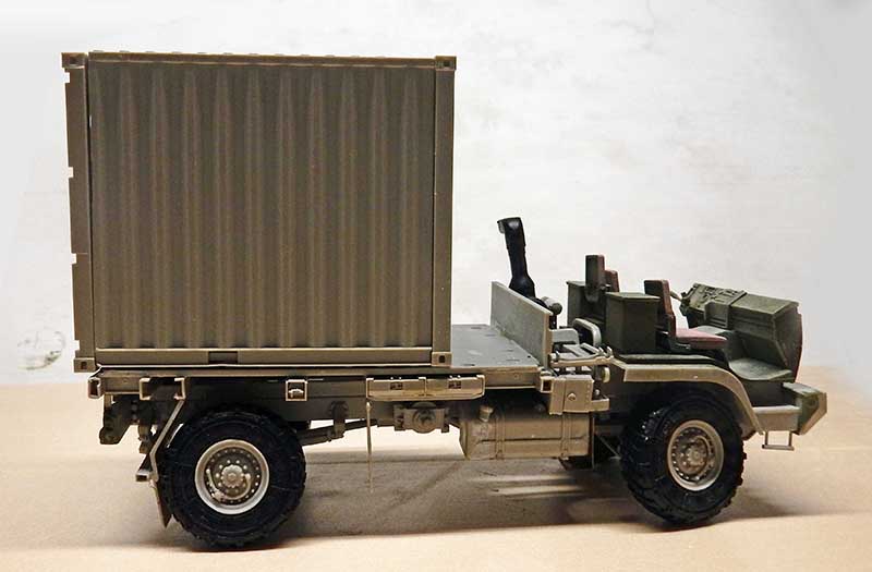 Maquette de camion militaire transportant un conteneur, vue de profil sur fond clair
