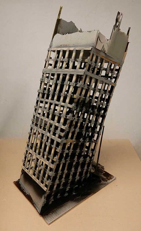 Maquette d'un gratte-ciel en ruine à la structure squelettique, sur socle en carton