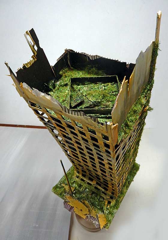 Maquette d'immeuble en ruine envahi par la végétation, sommet ouvert recouvert de mousse, ambiance The Last of Us