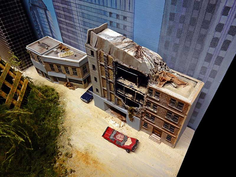 Diorama d'immeuble en ruine et voitures abandonnées dans une ville post-apocalyptique inspirée de The Last of Us