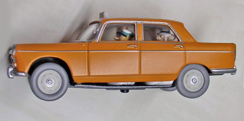 Maquette de Peugeot 404 orange vue de profil avec figurines de personnages à l'intérieur