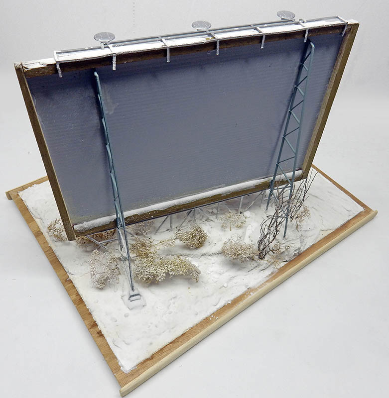 Maquette d'un panneau publicitaire vu de dos avec échelle sur socle enneigé