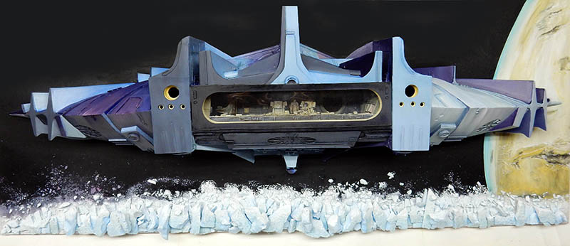 Diorama de l'astronef de Valérian survolant un champ d'astéroïdes glacés devant une planète