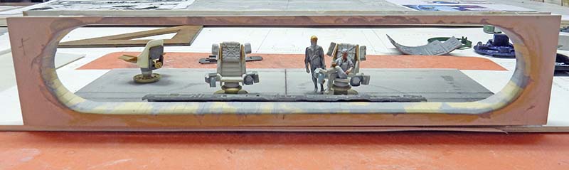 Coupe latérale du pont intérieur de l'astronef avec figurines et équipements en cours d'aménagement