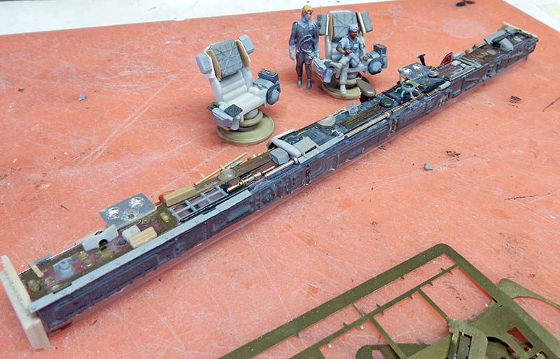Console latérale du cockpit peinte, avec sièges et figurines d'équipage en cours d'assemblage