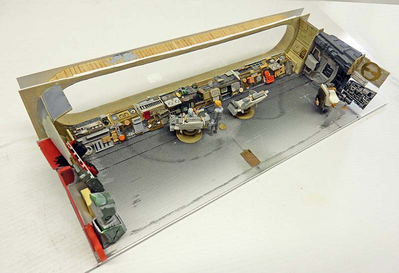 Intérieur du poste de pilotage de l'astronef en construction, consoles détaillées, sièges et figurines