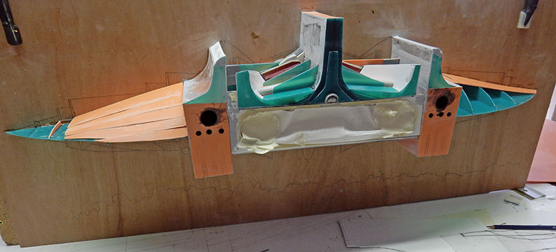 Structure en cours de montage de l'astronef, coque scratch turquoise et cuivre sur plan de travail
