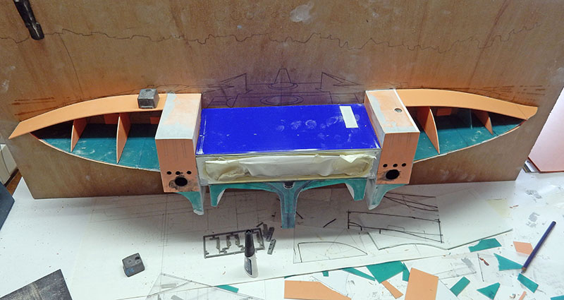Structure de l'astronef en cours d'assemblage sur plan de travail, plaques découpées en attente
