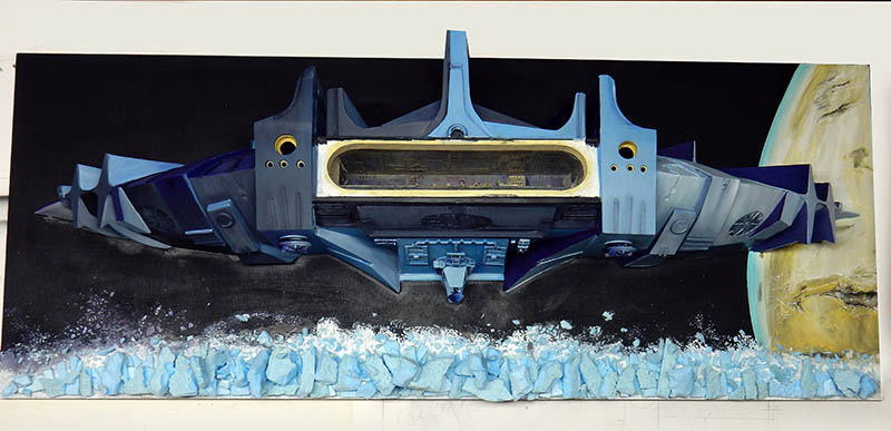 Diorama spatial de l'astronef bleu de Valérian devant une planète et des astéroïdes