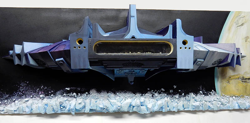 Diorama de l'astronef de Valérian survolant un champ d'astéroïdes glacés devant une planète