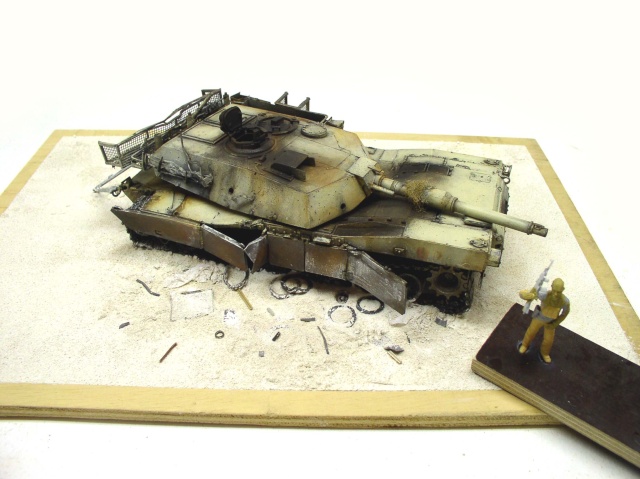 Maquette de char Abrams patiné sur diorama de sable avec figurine de soldat