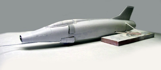 Fuselage de maquette d'avion à réaction gris non peint posé sur socle de bois