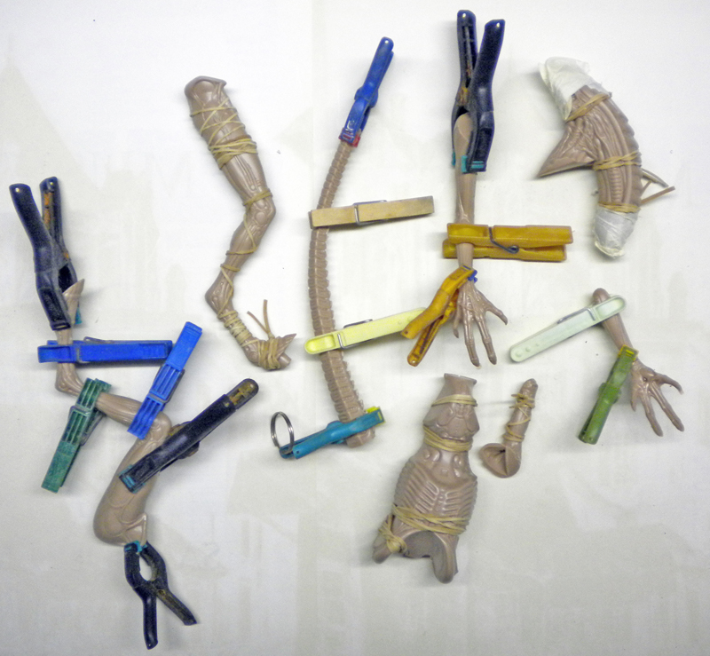 Pièces de maquette de l'Alien collées et maintenues par des pinces à linge pendant le séchage