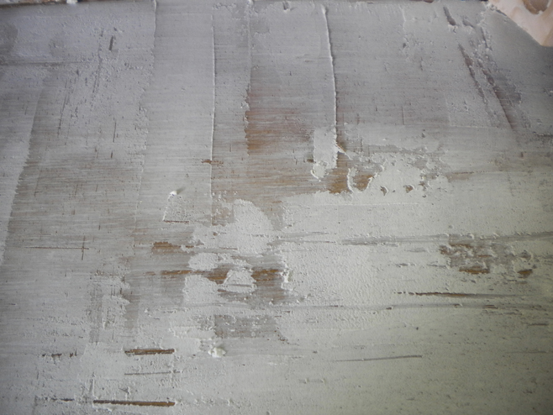 Surface de maquette enduite de mastic gris appliqué et poncé pour texturer une paroi