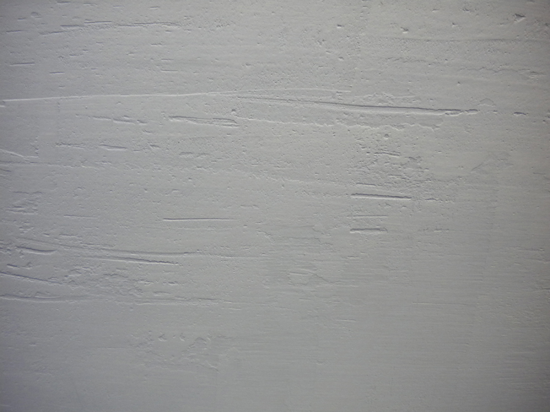 Surface de maquette recouverte d'apprêt blanc texturé montrant les marques de l'application