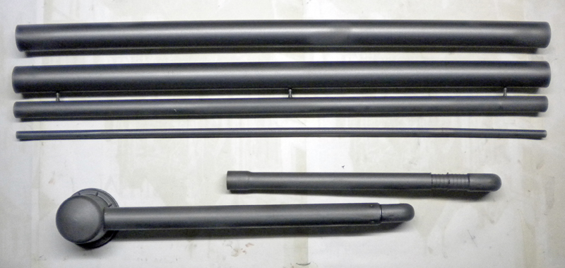 Tubes et tiges gris peints d'une maquette Alien 3 disposés sur un plan de travail