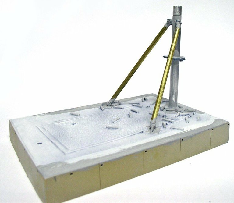 Socle de présentation en apprêt blanc avec mât et haubans du support de mitrailleuse
