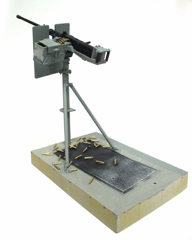 Mitrailleuse Browning M2 sur affût pivot, douilles éparpillées sur socle de présentation