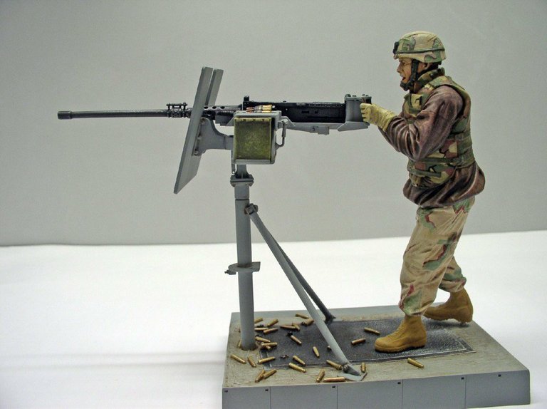 Diorama d'un soldat servant une mitrailleuse Browning M2 sur trépied, douilles éparpillées